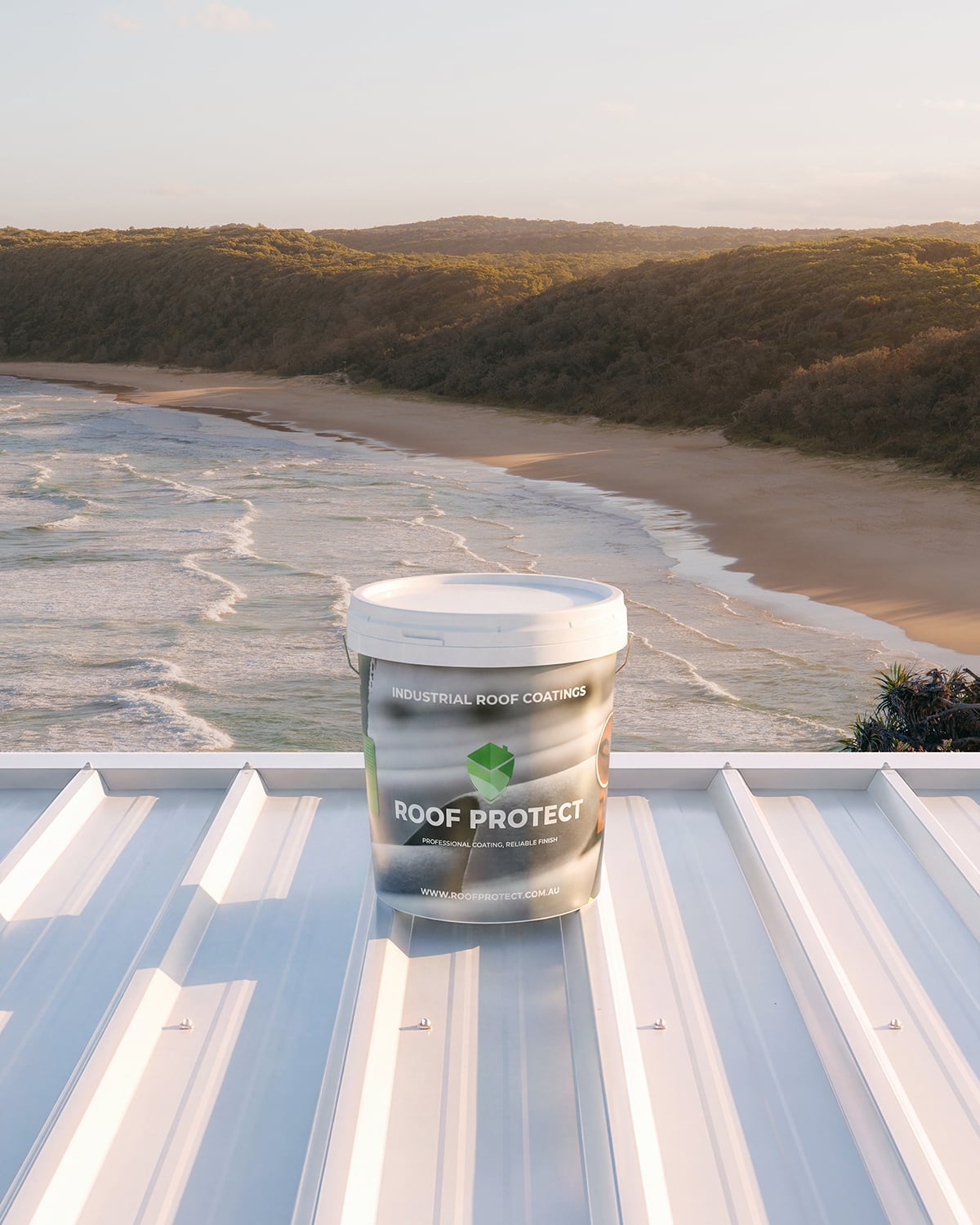Roof Protect bucket in silver packaging on a white metal roof overlooking the coast.