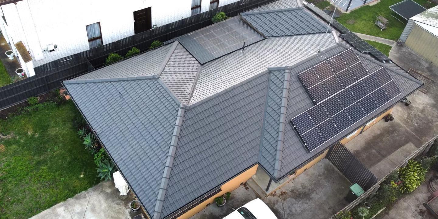 Tiled roof with an even grey finish and rooftop solar panels after restoration.
